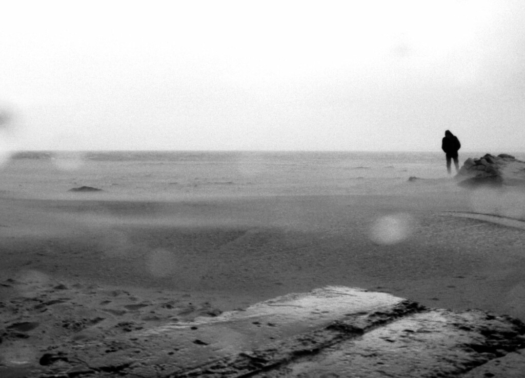 Ein Mann am Strand bei sehr schlechtem Wetter